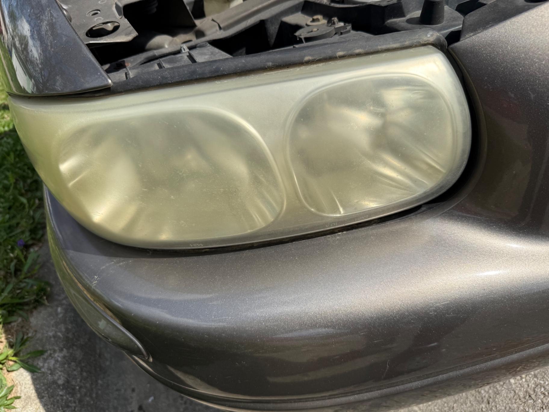 Fogged headlight assembly hiding the reflector and bulb before restoration