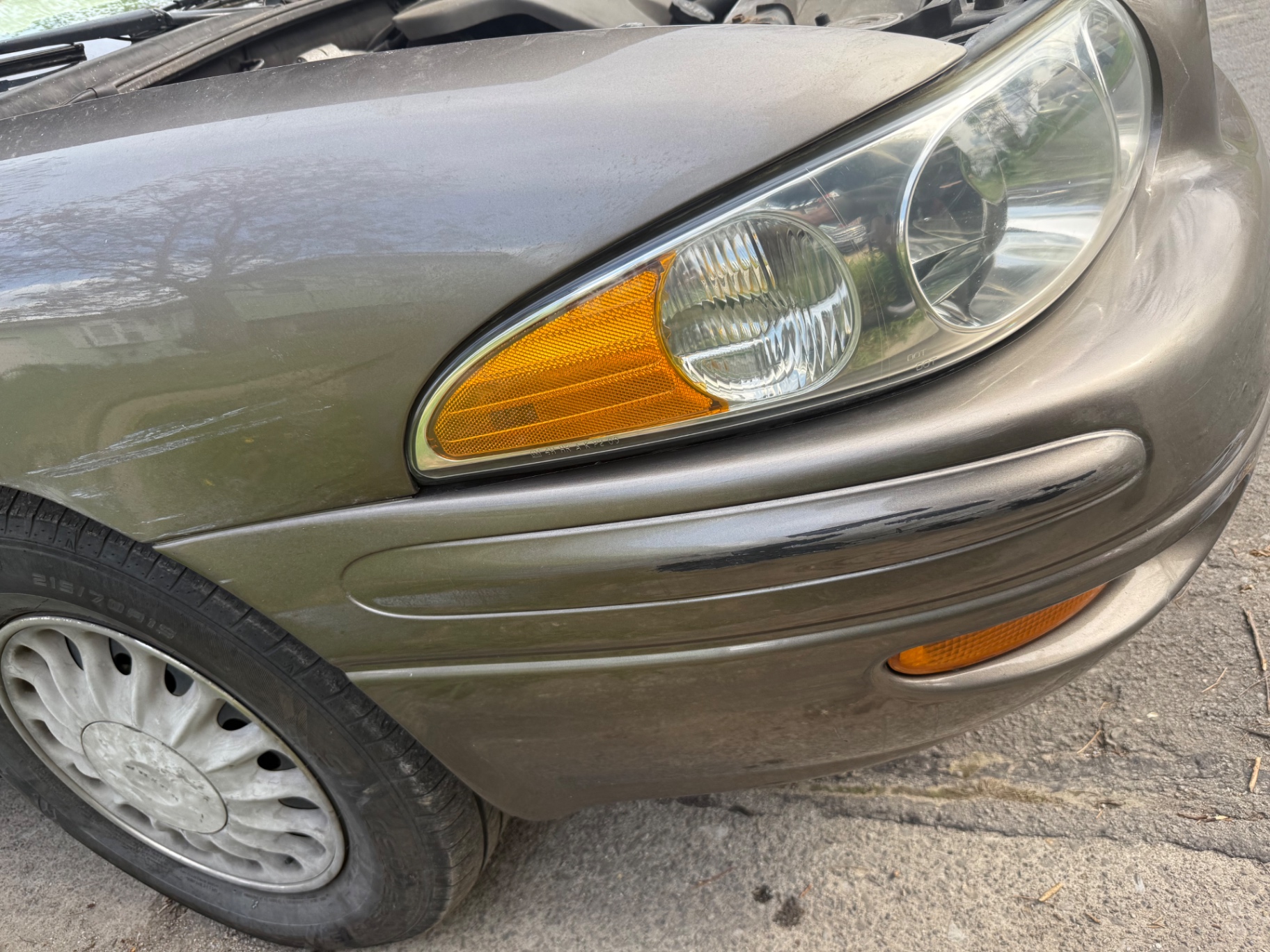 Restored passenger side headlight lens with clear optics and visible reflector after restoration