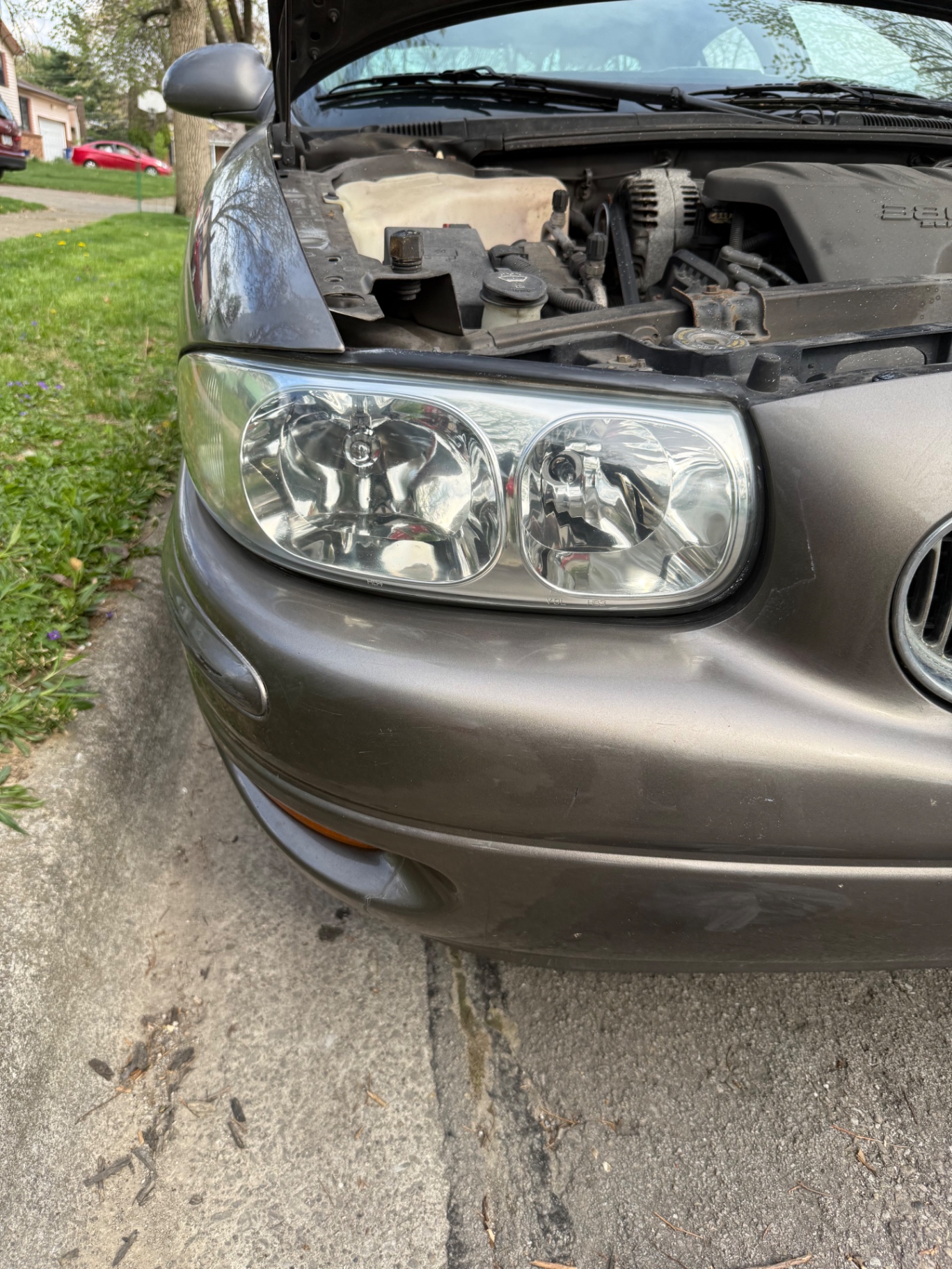 Clear, restored driver side headlight on the same gray Buick after mobile headlight restoration